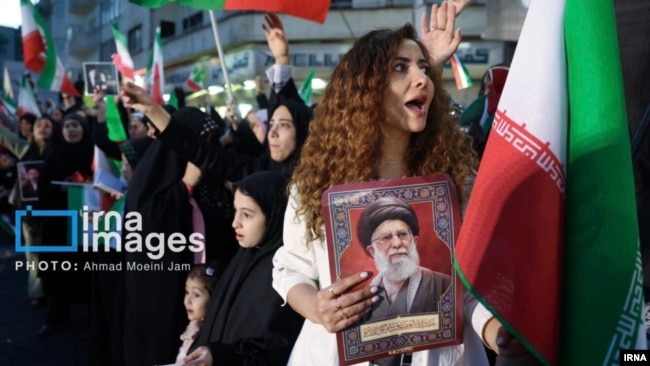 Keçən ay Tehranda keçirilən dövlət mitinqində hicabsız qadın mərhum Ali lider Əli Xameneinin portretini tutur.